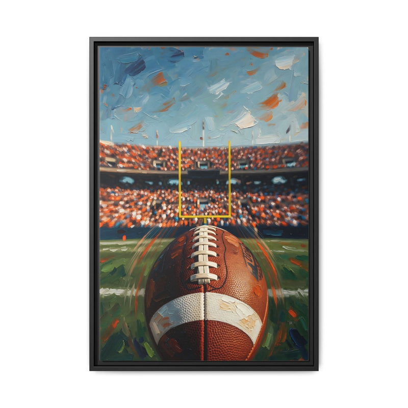 Black-framed canvas wall art with a football on the field under stadium lights.