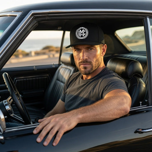 Black flat-bill snapback hat with white circular IM logo, worn by a man